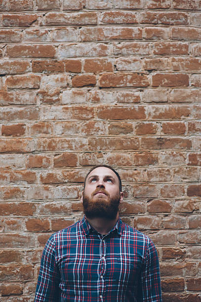 istock young man with beard against background of   old brick wall 611608846