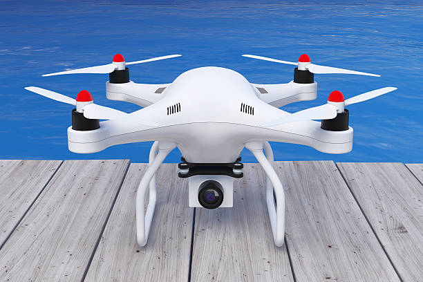 istock White Quadrocopter drone with Photo Camera in front of Ocean. 611609178
