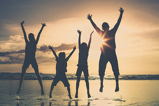 istock Father and children playing on the beach at the sunset 611611578