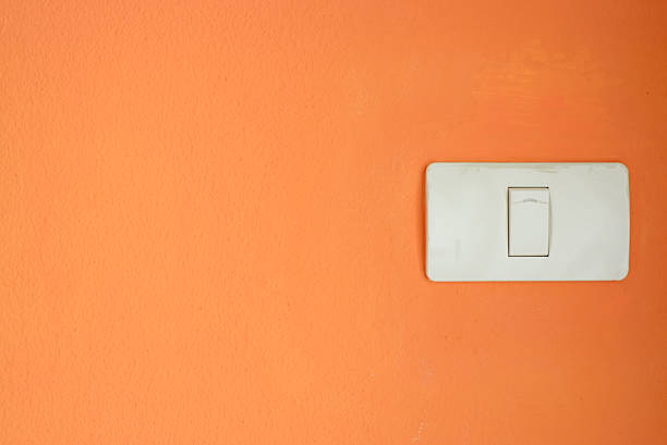 istock White light switch, turn on/off the lights on orange wal 611611996