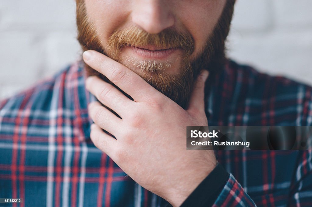 junger Mann berührt mit der Hand seinen Bart - Lizenzfrei Schnurrbart Stock-Foto