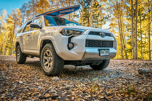 Basalt, CO, United States - September 27, 2016: Toyota 4Runner SUV (2016 Trail edition) carrying  a paddleboard on Frying Pan Road with fall colors in Colorado's Rocky Mountains