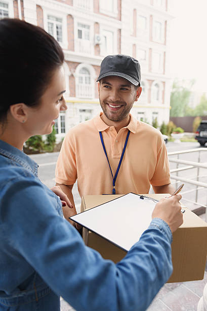 istock Courier making delivery to beautiful woman 611613756