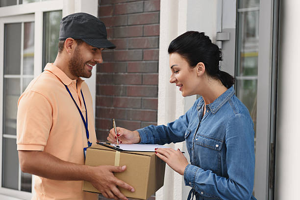 istock Courier making delivery to beautiful woman 611614002