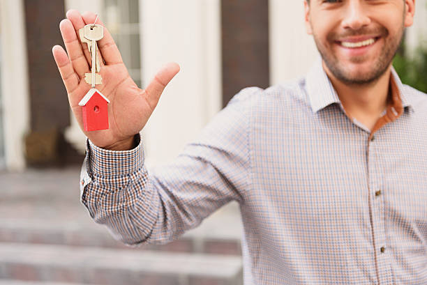 istock Smiling Real Estate Agent standing outside modern house 611614722