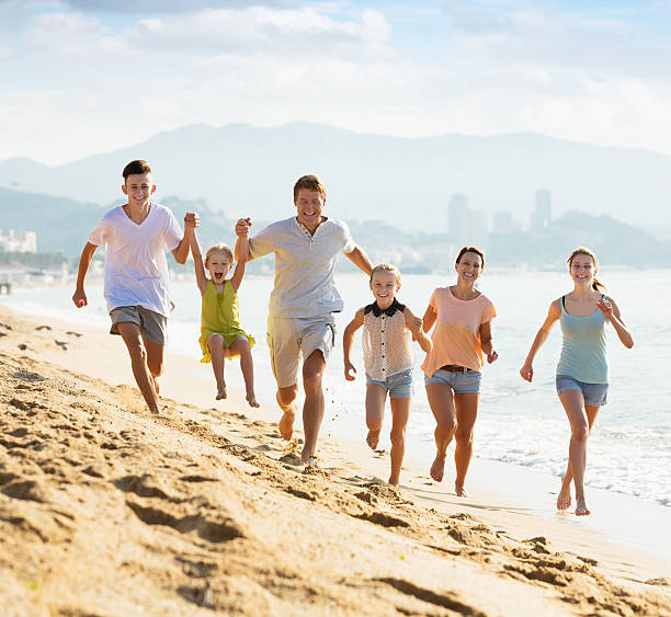 big family running on beach - family large american culture fun imagens e fotografias de stock