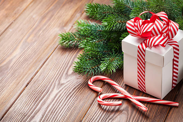 istock Christmas gift box, candy cane and fir tree branch 611618774