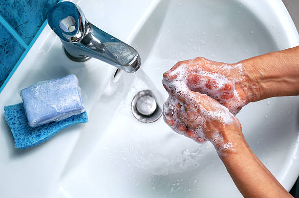 soapy hand over the washbasin stock photo