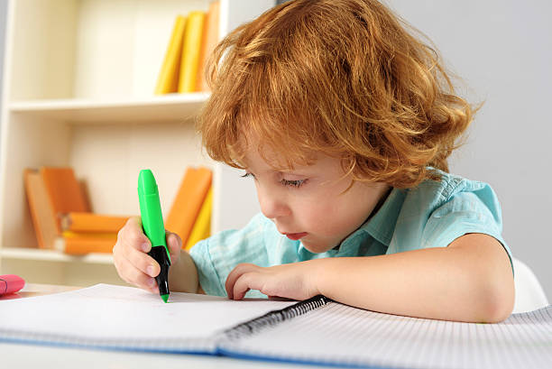 istock concentrated pupil sitting with marker 611622976