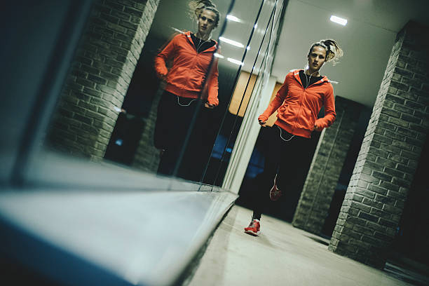 Running through the night Young female athlete running outdoors on a cold night girl jogging with power shoes stock pictures, royalty-free photos & images