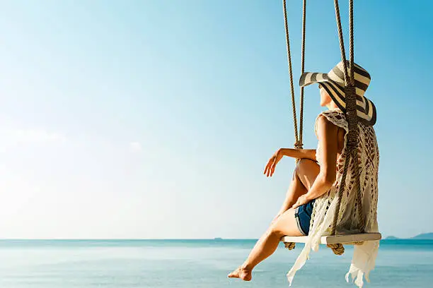 Woman sitting at tropical swing