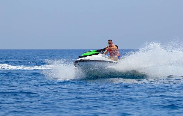 istock Tourists enjoy driving jetski on the ocean 611624810