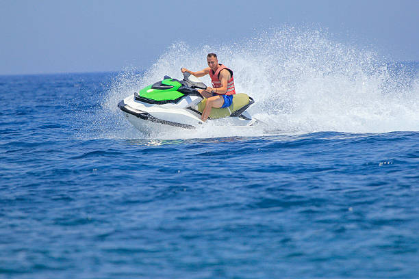 istock Tourists enjoy driving jetski on the ocean 611625200