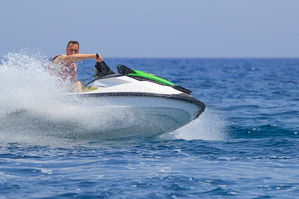 istock Tourists enjoy driving jetski on the ocean 611625436