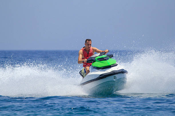 istock Tourists enjoy driving jetski on the ocean 611625488
