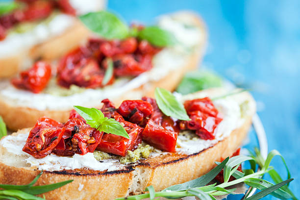 istock Bruschetta with cream cheese, pesto, basil and sun dried t 611626428