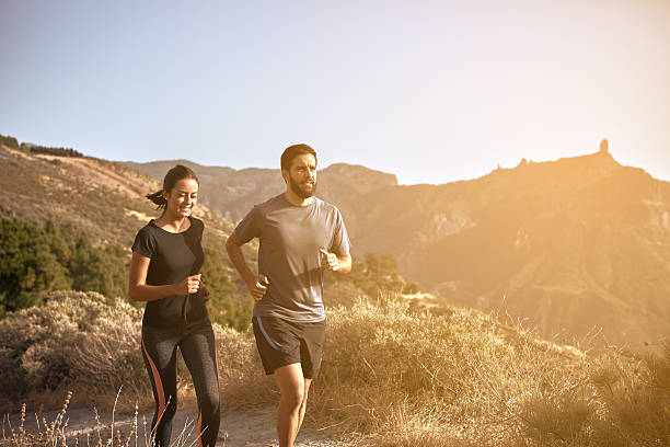 istock Young couple running in the mountains 611626446