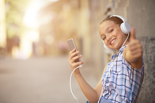 Young girl enjoy listening music on her smart phone