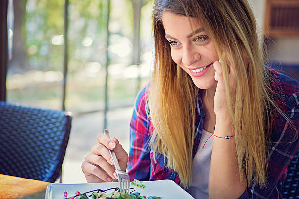 istock Young girl is talking using her mobile phone in restaurant 611627056