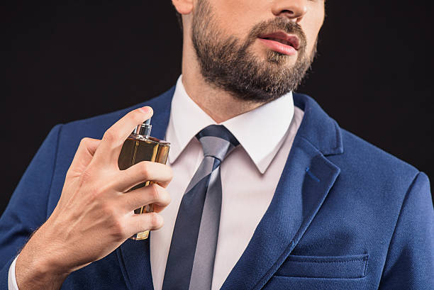 istock Attractive businessman wearing scent with pleasure 611628880
