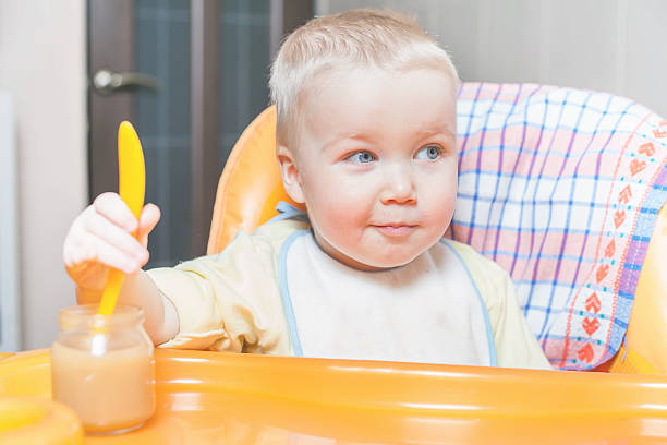 istock Happy child eating a fruit pure 611629278