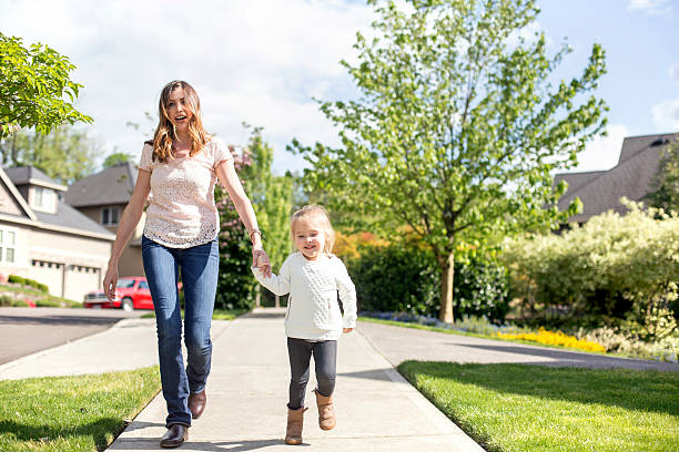 istock Young mother holding her daughters hand as they walk 611630120