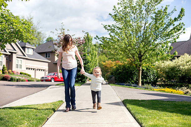 istock Young mother holding her daughters hand as they walk together 611630124
