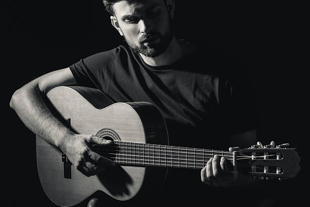 istock Inspired young man performing music on guitar 611630716