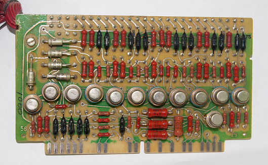 old vintage printed circuit board with electronic components closeup