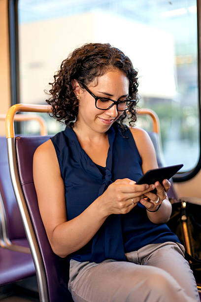 istock Ethnic young adult female using a tablet on public transit 611630872