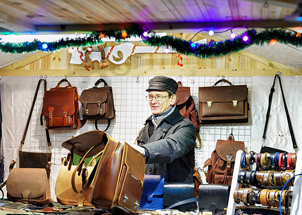 mężczyzna sprzedający ręcznie robione skórzane torby na wileńskim jarmarku bożonarodzeniowym - belt men gift night zdjęcia i obrazy z banku zdjęć