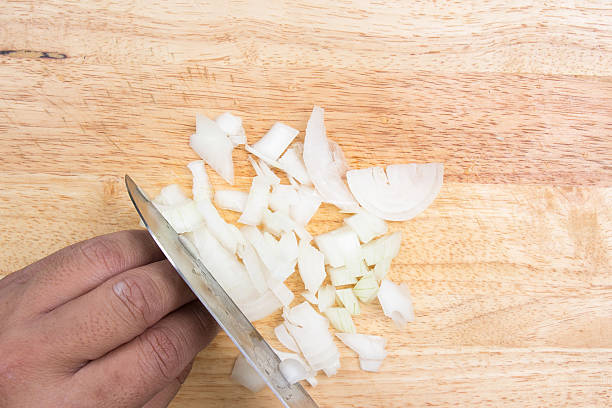 istock Chef slicing onion on wooden broad 611634784