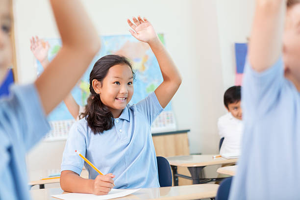 istock Cute Asian girl raises her hand in class 611634960