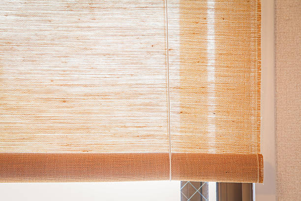 istock Brown fabric window blind in living room 611636700