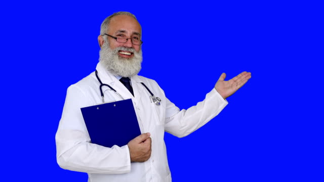 adult senior doctor showing copy space and smiling on a blue background