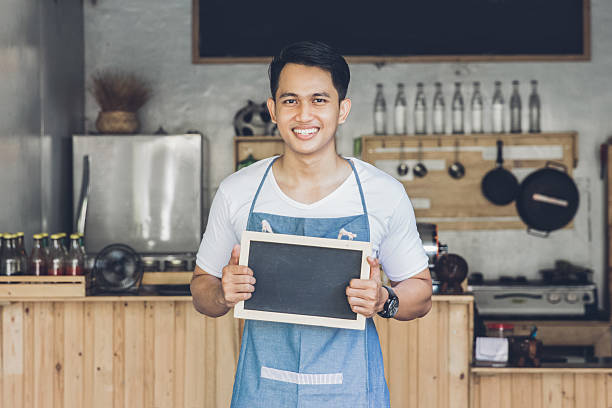 istock asian male cafe owner with blank board 611744388