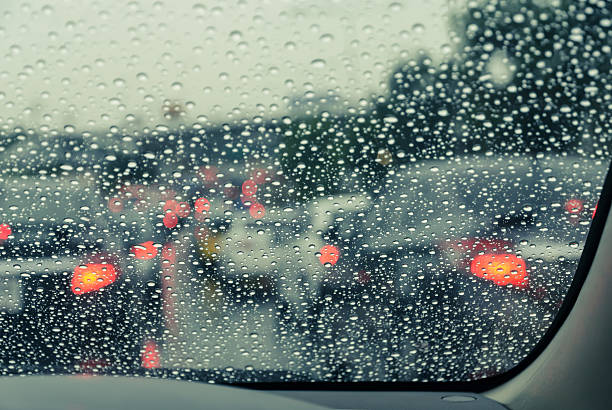 istock Blurry car seen through wet windscreen in rainy day 611745022