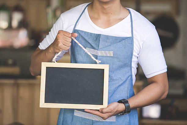 istock asian male cafe owner with blank board 611745330