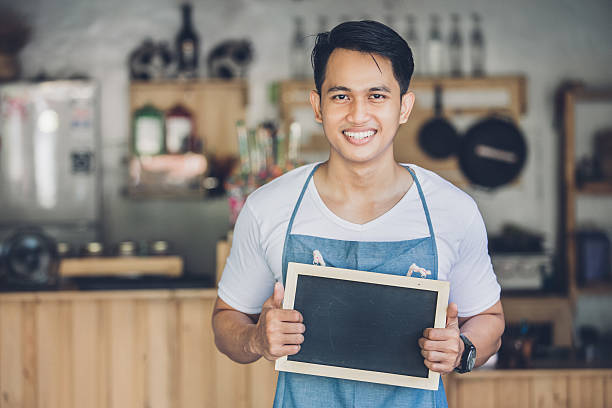 istock asian male cafe owner with blank board 611745396
