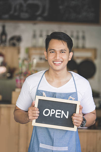 istock asian male cafe owner with blank board 611745460