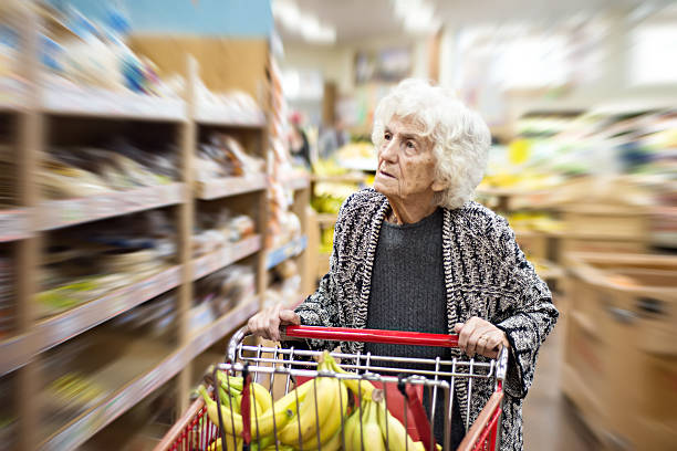 senior woman shopping nel negozio di alimentari - senior adult aging process supermarket shopping foto e immagini stock