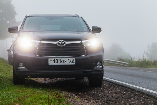 Saint-Petersburg, Russia - September 27, 2016: Black Toyota Highlander car stands on a roadside in foggy morning