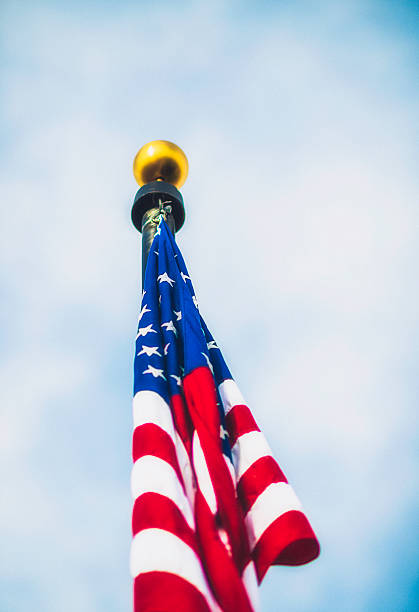 istock Patriotic American flag background with sky and clouds 611749568