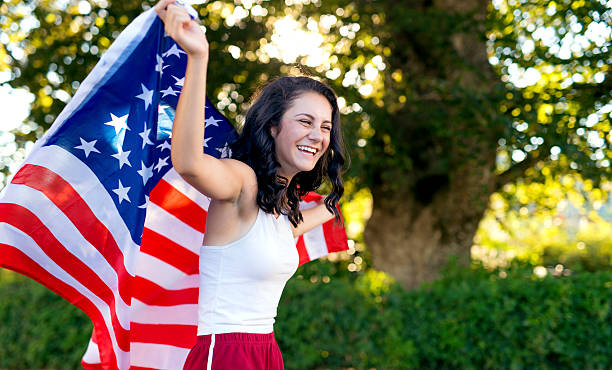 istock Young female holding an American flag and smiling 611751488