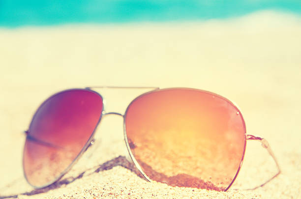 istock sunglass on the summer beach at ocean background 611752112