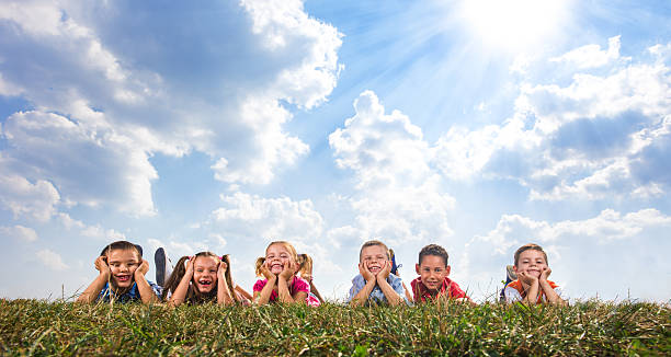 istock Panoramic view of cute children relaxing in grass. 611753664