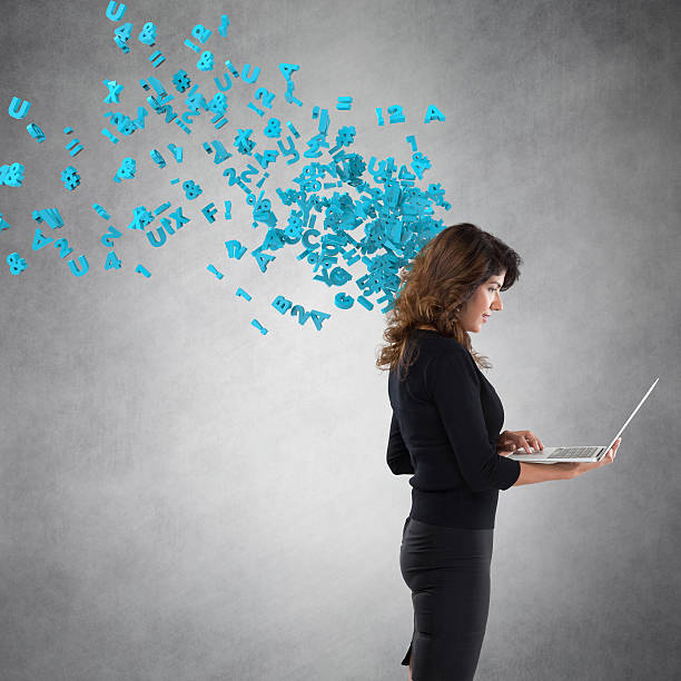 istock Businesswoman using laptop with flying alphabets 611757476