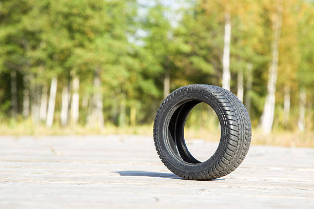 istock Black rubber tire on nature landscape background. 611757808