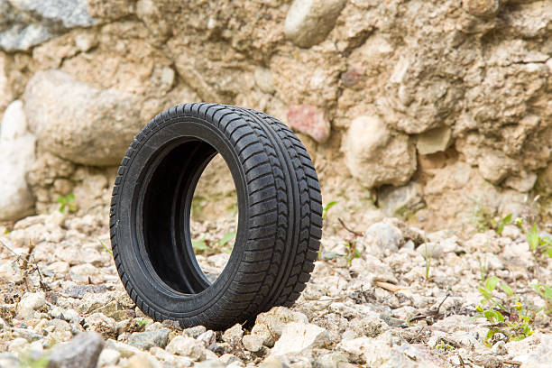 istock Black rubber tire on the stones. 611758744