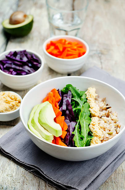 istock Rice bowl with red cabbage, carrots, avocado, arugula and hummus 611759522